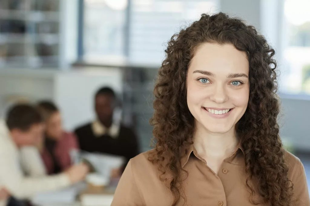 portrait-of-smiling-young-woman-in-library-FQ23P9M_art